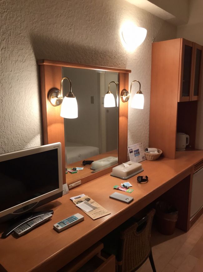 ベッドの向かい側が食器やポットなどが入っている棚と長めのデスクの上にテレビが置いてあり鏡が付いています。