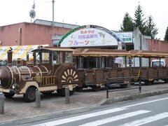 フルーツセンター前に停車中のブドウ号。

・料金 大人片道 400円　子供片道 200円　3歳未満・障害者（障害者手帳提示）無料
・1日券　大人 600円　子供 300円
・定員　54人
・途中停車駅　「フルーツセンター」「くだもの工房前」「芝生の広場」「フルーツアドベンチャー」「森の広場」「第1駐車場」