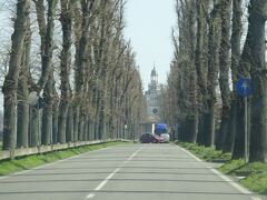 【チェルトーザ・ディ・パヴィアへの道】

午後の部の拝観を目指して、Certosa di Pavia ：チェルトーザ・ディ・パヴィアに寄った。パヴィア修道院という意味。西向きの正面入り口に向けて、街道筋から一直線の並木道が伸びている。

同名の駅は、こちら側から見ると、修道院の裏手、徒歩15分くらいの地点にある。ミラノとパヴィア間の通勤電車が、終日ほぼ30分間隔で走っている。