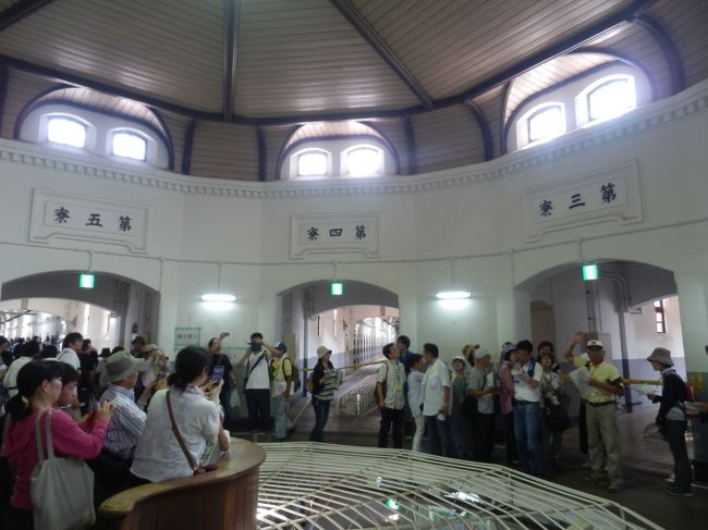 中央看守所の2階へ上がってきた．<br />左に看守の監視場所．その前方は鉄柵．<br />各舎房の廊下中央も鉄柵で1階が見える．<br />また各舎房の入口上には第一寮～第五寮の銘板も付く．