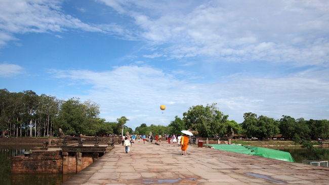 ルモは西参道入り口の外の<br />駐車場のようなところでおりる<br /><br />↑は西参道に入りお堀を渡る途中で<br />振り返って撮ったもの<br /><br />遠くに見える黄色い気球は<br />アンコールバルーンと呼ばれるもので<br />高度200mからアンコール遺跡を見渡せる<br />１回１５ドル。　上空で10分間停止する。<br /><br />ルモを降りたころ<br />雲のあいだからお日様が顔を出し<br />強烈な日差しが降り注いで来た