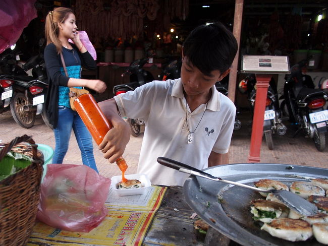 ひとついくらかと聞いたら<br />1500リエルだと教えてくれた<br />日本円でおよそ３８円<br /><br />ひとつお願いすると<br />焼き上がったまんじゅうに<br />醤油のようなものと<br />ホットソースをつけてくれる