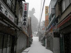 雪が降りしきる中、細い坂道を登り続けるのですが。
もはや普通の靴ではまともに歩けないほどの積雪っぷり。
滑って転ばないようソロリソロリと慎重に歩きます。
坂を登り切った角を右に曲がると、そこは食堂や土産物店が軒を連ねる小さな商店街でした。
その名は「町場通り」。
しかしながら残念なことに全店休業。
開いている店は一軒もありません。