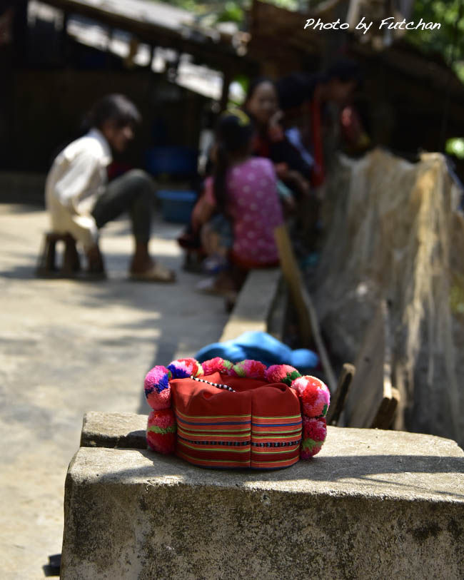 ＜ボンボンをあしらった帽子＞<br />日曜市の帰りランテンザオ族の村コムラ村に寄る。<br />家族で井戸端会議をしている前を通り過ぎる。<br />