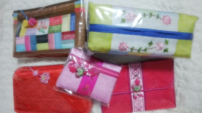 右上から<br />一目で気に入った蓮の花の刺繍入りのポシャギのポーチW8000。<br />通帳入れを新調、ピンクのケースW4000。<br />豚ちゃんが可愛い赤いポーチ(お土産用)W6000。<br />色合いが気に入った茶色いポーチ(お土産用)W4500。<br />真ん中のはおまけ。<br />