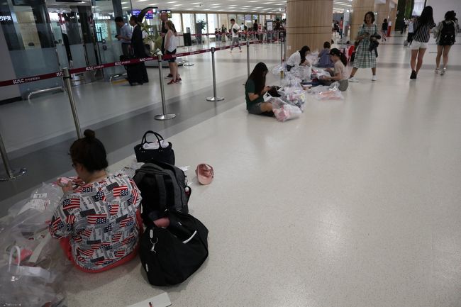 免税品を袋から出して、トランクに詰める人たち。韓国はやはり安いのでしょうか？座り込んで作業してました。