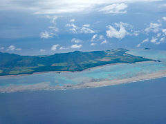 飛行時間約3時間、眼下に石垣島が見えてきました。サンゴ礁に囲まれた海岸線は、エメラルドグリーンです。期待に胸が膨らみます。平久保埼付近でしょうか。