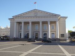 広場の南側の石造建造物がビリニュス市庁舎（Vilnius' Town Hall）です。1799年に改修されたネオゴシック方式の建物で、ビリニュス市の行事等でこの建物が利用されｔます。米国のジョージ・ブッシュ大統領や英国のエリザベス女王もこの市庁舎を訪れています。リトアニアを代表する歴史建造物です。