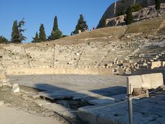 ディオニソス劇場 (Theatre of Dionysus)
アクロポリス南側は、酒と演劇の神ディオニソス（別名バッカス）の聖域で、丘の斜面を利用して造られた劇場と神殿があったところ。この劇場はギリシア最古のもので、紀元前5世紀ごろアイスキュロスやソフォクレス、エウリピデスらの3大詩人の悲劇やアリストファネスの喜劇が上演されていた。紀元前6～5世紀ごろ座席も舞台も木で作られていたが、紀元前4世紀に石で再建され、その後ローマ皇帝ネロの時代に大改築が行われた。約1万7000人を収容。前舞台を飾る浮彫りはディオニソス神話の場面を表しているそうです。