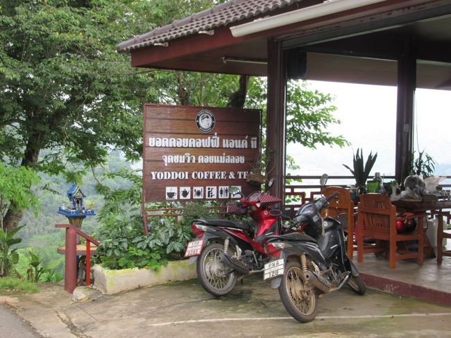 値段は決して観光地価格ではなく（コーヒー類は50THB），トイレも清潔。<br /><br />地元の客がバイクで立ち寄ってはコーヒーを買って帰る。中国系ばかりでなくタイヤイの顔もたくさんいる。<br /><br />この店の名は，店内や看板に「Yoddoi Coffee &amp; Tea」「PANA COFFEE DOI MAESALONG」「阿美咖啡店」の３種類の表記がありどれが正しいのかよく分からない。<br /><br />Google Mapでは「Yoddoi Coffee and Tea」で登録されている。<br />（座標：20.162536,99.648918）<br /><br />そういえばチェンライ市内の新時計台塔のすぐ近くにも「Yoddoi Coffee &amp; Tea」という店があったことを思い出す。