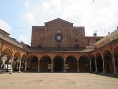 ”サンタ・マリア・デイ・セルヴィ教会(Basilica di Santa Maria dei Servi)”

正面から見るとこんな感じ。前庭をぐるりとキオストロが囲んでいる。
先ほども書いたが、左側は通りになっているので、教会のキオストロでもあり、通りのポルティコでもあるのだ。

1346年に建造され、その後長い年月をかけて拡張や改築、改修が行われ、16世紀に完成している。