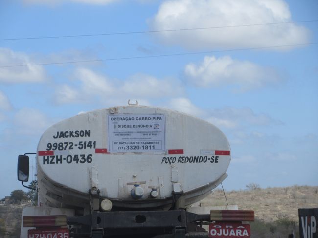 ポッソ・ヘドンドという街のタンクローリー<br />　ポッソ・ヘドンドとは、穴の中でグルグル回るという意味<br />　　変な名前の町名に大笑い<br />タンクローリー越しに見える地面は乾燥して真っ白の砂地<br />　石ころだらけでドミニカ移民を思い出した<br /><br />