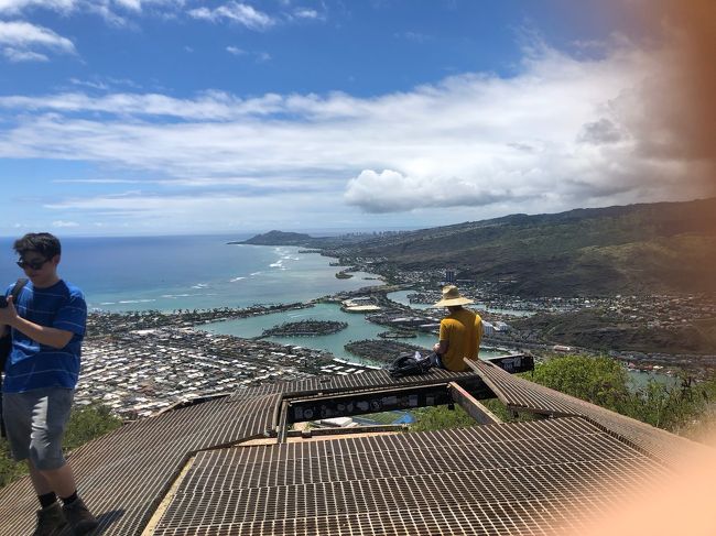 山頂からの眺めはサイコー<br />右側にオジさんの指写っちゃってるけど、興奮してたのね、そういうことにしとこうね<br /><br />登っている最中は、相当キツかったらしく、地元らしき若い女の子達に先を“譲った”そうです<br />“譲った”のね、そう言うことにしとこうね<br /><br />物は言いよう<br /><br />ダイヤモンドヘッドには毎朝登りたいと言ってた主人も流石に疲労感で山頂おにぎりを断念したそうです<br />この日は、時折雨も降って湿度高めの高気温だったし、リュックの中でホカホカ状態だったおにぎり断念は懸命だった気もします<br /><br />↑上の方で、“無事バイクがレンタル出来た”の画像が間違っていたようです<br />借りたのは、