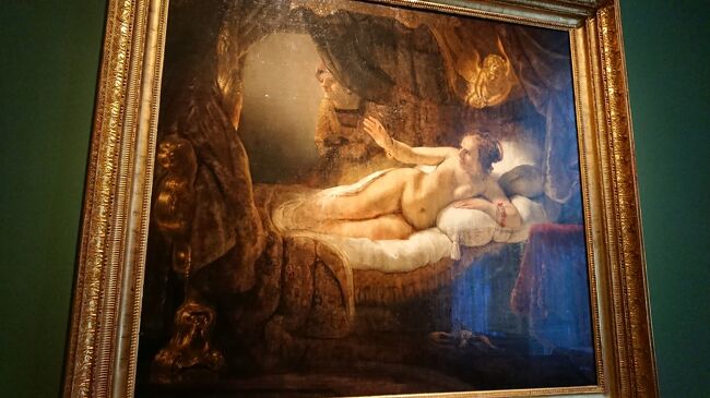 レンブラント《1606-1669》ダナエ　1636　カンバス　油彩　185×202.5<br />Map254<br />この作品はレンブラントの代表作の一つとして名高い。古代ギリシア神話によれば、アルゴス王の娘、美女ダナエは一生を一人で過ごす運命にあった。孫の手にかかって死ぬだろうと神託を受けた父王アクリシウスが彼女を塔に幽閉したからだ。しかしダナエの美しさに惑わされた主神ゼウスが黄金の雨に姿を変えて塔に忍び込み、その結果英雄ペルセウスが生まれる。そして、競技会の際にそれと知らずにアクリシウス、つまり自分の祖父を殺してしまう。1985年、この作品は精神異常者の手によって硝酸をかけられ、ナイフ傷を２か所に受ける。損傷はひどく、この名作の美術品としての歴史は幕を閉じたかに思われた。しかし、エルミタージュの修復員による12年間の必死の努力の末、ダナエは蘇り、展示室に戻ることを得た。（土産本）