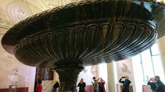 １階に降りてきました。大人気、大迫力、コルヴァンの飾り鉢<br />飾りなのかｗ分解できるのかｗ<br />ストリートビューは　59.941216, 30.316490<br /><br />Map128<br />コルィヴァニ壺　1847<br />ロシア石彫芸術の最高峰コルィヴァニ壺は新エルミタージュ2階の展示室の飾りとして制作された。しかし19トンという重量のために予定通りの場所に置くことができず、1階の古代美術展示室の一つに飾られた。<br />アルタイの研磨工場ではこの壺の制作に12年もの月日を投じた。高さ2.5メートル以上、一枚岩から成る碗の直径は約5メートルにもなる。それぞれ一枚岩から掘り出された五つの部分から成り、分解できるようになっている。（土産本）