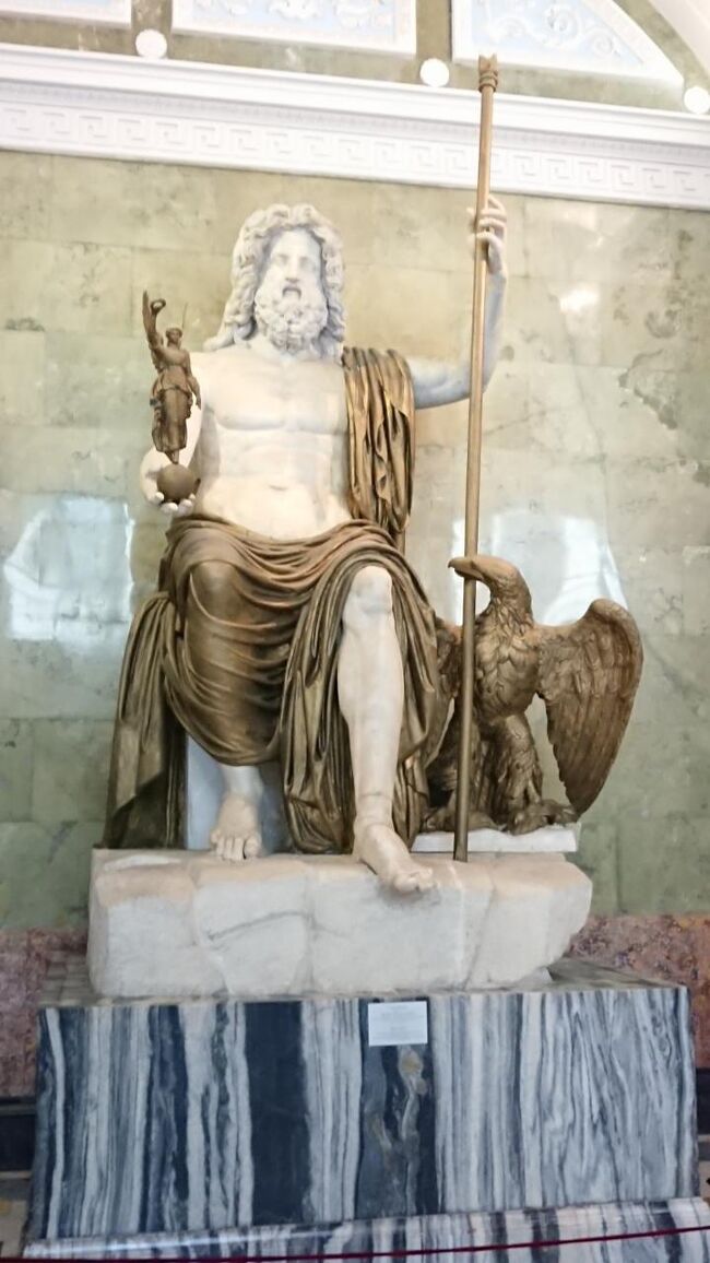 Map107<br />現在、ジュピターの間ではローマ肖像彫刻が展示される。部屋名はかつて主神ジュピター像に由来する。この部屋では19世紀に西欧彫刻が飾られていたことから、アーチ型の天井にミケランジェロやトルヴァルドセン・カノーヴァ、マルトス、そしてラウフというヨーロッパとロシアの代表的芸術家の高浮彫が施された白い浮彫の飾板が嵌められている。（土産本）<br />ジュピター像　前1世紀、大理石、石膏　<br />19世紀にローマ近郊で古代神殿が発掘された際に出土したジュピター像。紀元前5世紀の大彫刻家フェティウスの代表作の一つに数えられながら、現存しない古代作品を元とする。フェティウスのゼウス像は象牙と金でできていたのに対し、エルミタージュのジュピター像は当初大理石と鍍金木材を使っていた。しかし、木材は保存されず、その部分は木を真似て着色された石膏に替えられている。<br /><br />写真撮るとしょぼくなるけど実物のが威厳あった<br />Googlemapの場所　59.941216, 30.316490<br /><br />