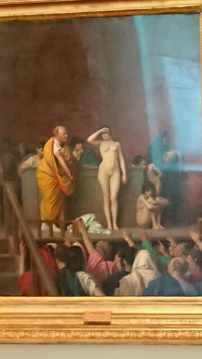 J.=L.ジェローム《1824-1904》<br />競にかけられる女奴隷　1884　カンバス　油彩　92×74<br />サロン画の代表格ジェロームはサロン《官展》入選、レジオン・ドヌール勲章受勲、そしてアカデミー正会員選出と、最も高い社会的な評価を得るに達した。『競にかけられる女奴隷』は『ローマの人身売買』という題で1884年にサロンに出展され、絶大な人気を博した作品。（土産本）<br /><br />今の基準で見るのも違う気がしますがすごく目立つ衝撃的な絵でした。ローマの、を消したんですね。もし日本の、と書いてあるのを消したらどうなるだろう。隣国が大騒ぎしそう。豪華に着飾った貴族や皇族の絵と対比してみてください。