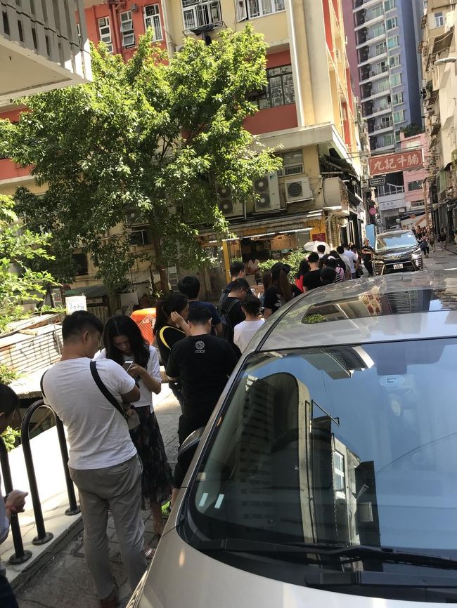 お昼は後輩が行きたいという有名店、九記牛腩へ。<br />開店前で既にかなりの行列。<br /><br />一人だと並ばないですが、せっかくなので待ちます。<br />しかし暑い。