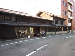 白沢煎餅店から肴町へぶらぶら行きます～、

黒壁と貼り瓦に格子戸の低い軒が続く荒物屋は「ござ九・森九商店」、
老舗の雑貨商らしく重厚な家屋は豪商に相応しい趣きですね。
店先には箒が並べられてます。