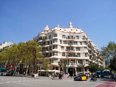 カサ・ミラ
1906から1910年バルセロナが近代化を遂げた最重要時期に、目抜き通りのグラシア通りに建設。
地中海やカタルーニャの雪山イメージの波打つ外観が印象的で、センセーショナルな話題を巻き起こしたダイナミック住居。
屋上からはエシャンブラ地区の基盤の目のような街並みが見渡せ、左にサグラダ・ファミリア、右にティピダボの丘が塔の間から見える定番スポット。

青空と高級感あるストリートに映える白い建物だった。