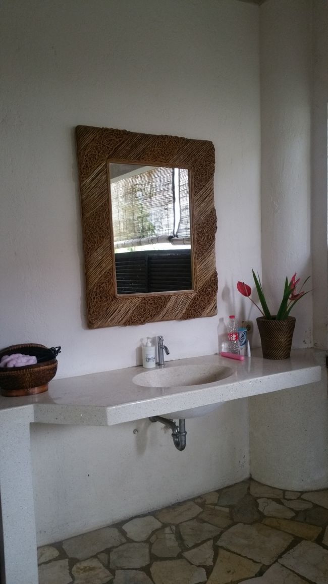 バスルームの扉も閂になっていて、開けると洗面台があります。<br /><br />広々とした洗面台でボウルも大きめ。<br /><br />鏡も大きめでちょうど良い位置に設置されてます。<br /><br />洗面台にお花も飾られてて素敵...♪*ﾟ<br /><br />蛇口が変わったタイプで水がシャワーで出てくるんです。<br /><br />唯一の難点が蛇口から出る水が跳ねて服が濡れるというｗｗｗ<br /><br />お部屋の謎のテーブルの上にあった蓋付きのカゴを、小物入れとして使わせてもらい、ヘアビタミンやブラシやヘアアイロンなどを入れてました。