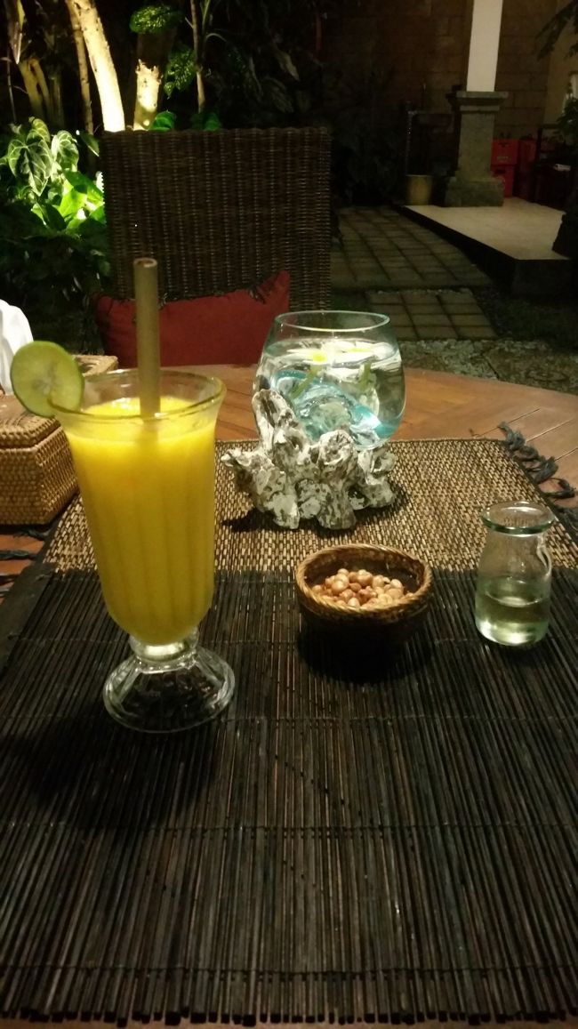荷解きと荷物を所定の位置に設置すると辺りは暗くなってきました。<br /><br />あぁ…ご飯食べに行かないとなぁと、Pharmacyにも行ってヘアビタミンも買わないとなぁとなり、部屋を出ると奥様の Ibu Dewi さんに会いました。<br /><br />こちらの奥様のIbu Dewiさん素敵な方でした。<br /><br />ご主人様のAgungさん同様英語が堪能でした。<br /><br />Ibu Dewiさんと挨拶をしてdinnerへ出掛けると話すと、お庭でカフェもやってるからいつでも食べれるわよ~と、メニューを見せてくれたので今食べれるか？と聞いたらOKだったのでオーダーして、ちょっくらそこのGuardian pharmacyに行ってくるわと言ってPuri Cantikを後にしました。<br /><br />ヘアビタミンと石鹸を買って戻って、カフェで着席すると今宵のウブド到着日の初dinnerの始まりです。<br /><br />まずはバリと言ったら雨季と言ったらマンゴージュースです(⁎˃ᴗ˂⁎)<br /><br />ライムも付いてきてちゃんとしてる~~~٩(*Ü*)۶<br /><br />ご飯もオーダーするとお通しみたいなナッツが出てきます。<br /><br />マンゴージュースをごくごくごく(p◎q )<br /><br />ん？<br /><br />なんか瓜っぽさがあるというか、苦さがあるというか、ちとまろやかなマンゴーではなかった模様。<br /><br />ナッツをいただいてみますかね…<br /><br />( '༥'  )ŧ‹”ŧ‹”ŧ‹”ŧ‹”ŧ‹”ŧ‹”ŧ‹”ŧ‹”ŧ‹”ŧ‹”<br /><br />なにこれ~~~！！！<br /><br />うんまいやんけっ(ᵒ͈̑ڡᵒ͈̑ )<br /><br />バリで美味しいナッツに出会ったの初めてだわ⸜(*´꒳`*)⸝