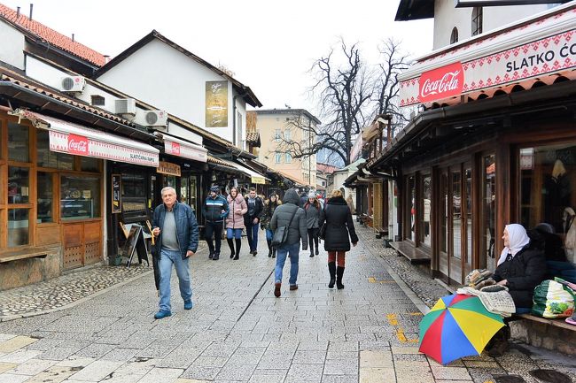 バシュチャルシヤをぶらぶら。<br /><br />カラフルな傘のそばのおばあさんは、手編みの手袋や靴下を売っています。