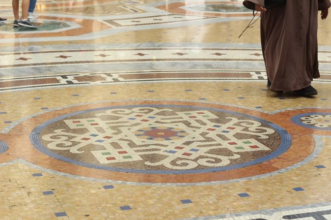 地面のモザイクタイル？も素敵な模様がたくさんです。そして右上の人は修道士さんっぽい？写真なかったけど、中央のモザイク画はイタリア王国の紋章、その周囲にミラノ、トリノ、フィレンツェ、ローマの紋章が描かれています。