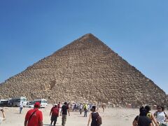 続いてエジプトのハイライト「クフ王のピラミッド」です。
ピラミッド群の中で一番綺麗な正三角形とのこと。
よく見るとピラミッドの頂点に鉄線が刺さっています。
頂点は少し崩れており、元の高さはここまであったことを示す鉄線とのことです。
また、ガイドさんからの注意点として、物売りが多く、物売りからあげると言われても受け取ってはいけないとのこと。
後からお金を請求されるそうです。