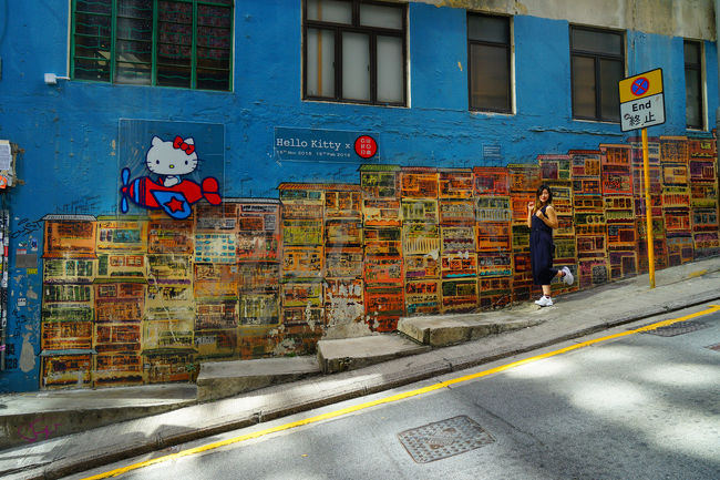 香港の密集住宅街を描いたと言います。観光客が記念スナップをしています。何故キティーチャンが？。