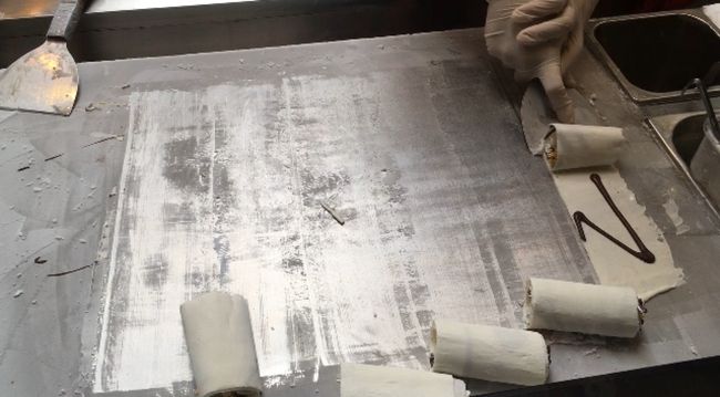 日本でも人気のロールアイス<br />数種類の中からアイスを選んだら、<br />パネルに名前を入れてと言われる。<br />チョコレートソースで名前を書いて<br />トッピングと一緒にクルクルしてくれる