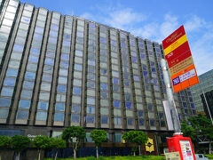 滞在の「カオルーン・シャングリ・ラ香港」です。ハーバーサイドから全景を写したものです。右サイドのオレンジ色と標識は、バス停留所です。