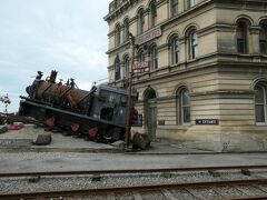 錆びついた線路の脇の建物の前に蒸気機関車が展示されていました。