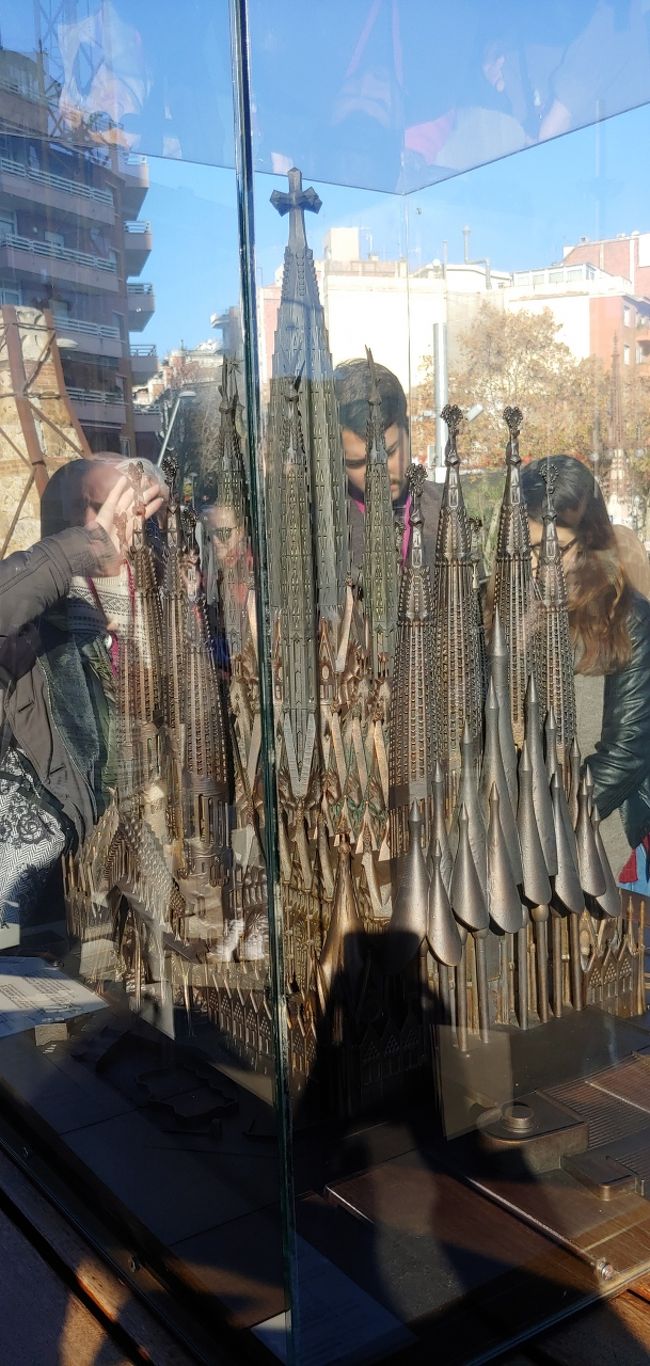 ファサード手前のスペースに完成した際の全体像が飾ってありました。<br /><br />手前に見えている栄光のファサード、そして中央部の塔上半分がまだ未完成です。<br /><br />2026年、ガウディ生誕100周年に合わせて完成との事です。<br /><br />その時にまた行きたいですね！<br /><br /><br />イヤホンガイドで勉強し、中に入ります。<br /><br /><br />あっ、ちなみに日差しがすごく眩しいので真っ黒なサングラス必須です。