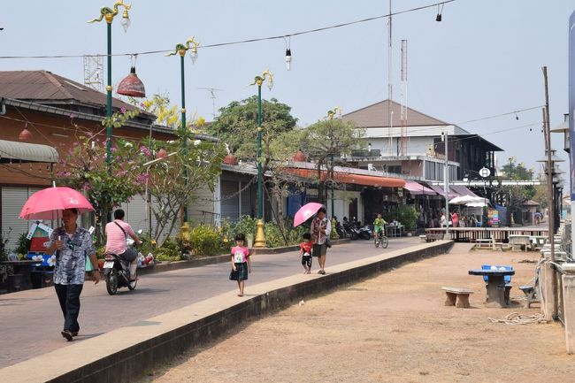 ノンカーイまでは1時間程で着いてしまい、先ずラオス行の人達を友好橋の前で降ろした後、数km離れたターミナルに移動します。そこから何本か道路を横切ると、メコン川に突き当たります。川沿いのレストラン＆飲み屋さん通りは、朝早いので開いていません。日曜日で、家族連れが散歩してるのが見えました。夜は賑やかになりそうで、照明の電球が道を横切っています。