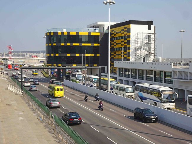 で、実はこの送迎バスターミナルに使われている場所は毎年１１月に開かれる「マカオグランプリレース」のメインパドック／作業用ピットなんですね。　黒いガラス張りのビルはレースコントロール、手前の道路部分はメインストレートです。