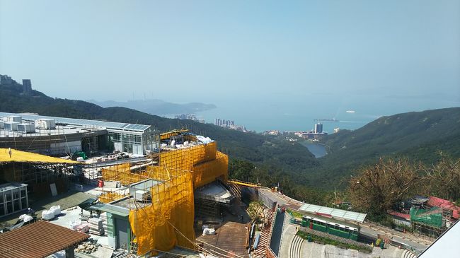 ビルと反対側を見てみると遠くに海が見えました。<br />山の上ではまだ建物を建設中です。