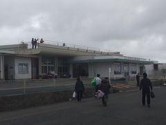 沖永良部空港（えらぶゆりの島空港）に到着。
降機後は歩いてターミナルに向かいます。
離島というか、小さい空港ですので、着陸後の誘導路はありません。滑走路と、その真ん中らへんに、駐機場とターミナルがあるだけ。
なので、着陸したあとは、滑走路上で、Uターンして滑走路を走り、駐機場に入ります。
離陸時も、滑走路を端まで走ってUターン、それから離陸となります。
便数も少ない、機体も小さいのでできることですね。
