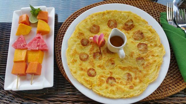 朝食はバナナパンケーキにしてみました、<br /><br />前日の夜にオーダーするシステムです。<br /><br />朝食のメニューの詳細は<br /><br />コーヒーか紅茶、アイスかホット<br />その日のフルーツジュース<br />フルーツ盛り<br />メインでナシゴレンかミーゴレン、オムレツとパン、シリアルなどから選べます。<br /><br />パンケーキは無難で普通でした。<br /><br />ここの朝食の良いところはフルーツジュースも付いてくること!!!<br /><br />朝は喉が渇くので水分をごくごく飲みたいのです(〃’σ`ｺﾞｸｯｯ..<br /><br />しかもフルーツジュースおいちい(ᵒ͈̑ڡᵒ͈̑ )<br /><br />フルーツも串に刺さって見た目お洒落♪♪<br /><br />雨季だからマンゴーが美味しくって( *ˊᵕˋ)ɢᵒᵒᵈ<br /><br />フルーツを美味しくいただけて良かったですꉂꉂ"̮˖笑"̮˖<br /><br />この日はスパの予約をしてると勘違いしてMandala Desaのウブドまで送迎で行きました。<br /><br />ドライバーは若い男の子のAgung。<br /><br />他のゲストと同じ時間にしてほしいと言われたので、早い時間にウブドに到着。<br /><br />時間潰しにハノマンのKafeに。<br /><br />二階席が良いとの情報があったので、上良い??とジェスチャーで聞くと、スタッフの女の子が何やら言ってるけどUbudiはわかんなくて( ˙꒳​˙  )???<br /><br />そしたら別のスタッフの男性が一言 CLOSE と言ったので状況を把握して1階席に。<br /><br />その男性スタッフが感じ悪くて、英語もろくに話せないのに来んなみたいな、横柄な態度取られて最悪な接客態度ʅ(๑  ᷄ω ᷅ )ʃ<br /><br />別の店にすれば良かったと後悔したわ( ˙³˙)⇝<br /><br />朝ごはんは食べたからお腹は空いてないからドリンクだけだったけど。<br /><br />なんだか飲みたいものがなくて...<br /><br />メニューがわかりづらいし...<br /><br />迷った挙句バナナジュース的なものをオーダーしました。<br /><br />ここも欧米人ばかりで朝ご飯食べてます。<br /><br />しかもお洒落系カフェｗｗｗ<br /><br />またやっちまいましたᔪ(°ᐤ°)ᔭᐤᑋ<br /><br />あれ程お洒落系は居心地悪いから止めようと思ったのに...ᔪ(°◊°҂)ᔭ!! ℕꇎ─!!<br /><br />ちびちびバナナジュースを飲んでいると、他のゲストが2階に上がってくではないか??<br /><br />時間で開けてるの??<br /><br />それとも人見て入れてるの??<br /><br />まっ、いいかｗｗｗ<br /><br />時間も潰せたし少し早いけど両替しに行きがてらスパへ行くとしてお会計しました。<br /><br />他のスタッフは感じ良かったのにね。<br /><br />両替しにハノマンを南下してプンゴセカンへ。<br /><br />新しいレストランなんかも出来てて。<br /><br />両替したらまたプンゴセカンを北上してモンフォレへ。<br /><br />Angga Sarira Spa &amp; Wellnessに着いて気が付きました!!!<br /><br />予約日間違えてると...<br /><br />ワヤン②がいてどうしたの??と声掛けてくれて、予約日間違えたわ明日よね??、そうよ明日よ、OKまたねと後にしたものの、送迎の時間までかなりある。<br /><br />またモンフォレをブラブラしてたら暑くなって休憩しにカフェに入ったらスコール☔☔☔<br /><br />雨宿りしてお迎え場所のココスーパーマーケットまで行ってお買い物。<br /><br />マンゴージュースとマンゴーとドラゴンフルーツ、スクラブとアロマオイルを買いました。<br /><br />それでも迎えの時間まで1時間以上あるし...<br /><br />ココスーパーマーケットの駐車場にトランスポートの人が沢山いるので、買い物終わった後にいくらで行ってくれるか聞いたら、なんと!!! Rp200.000!!!<br /><br />高い高いって言っても車だからと言い張るし、まけてくれなかったから迎えを待つと断って、スーパーマーケットのベンチに向かおうと歩きだしたら、Hey!! Hey!!と呼び止められて...<br /><br />振り向くとRp100.000でいいよと言ってくれた!!!<br /><br />お迎え断る電話もしてもらって、本当にRp100.000でいいのね??と念押しして、さあ行こうとしたらバイクだけどねと...<br /><br />バイクかあ、まっいいかｗｗｗ<br /><br />ということでバイクで帰ってきました🚲<br />