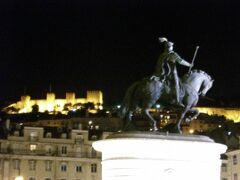 “ジョアン1世”の騎馬像が建ち、後ろにはライトアップされたサン・ジョルジェ城。