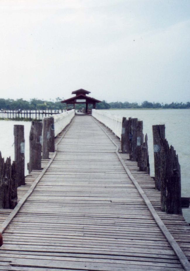 マンダレーの近郊にある「アマラプラのウー・ベイン橋」に立ち寄った。<br />タウンタマン湖に架かる200年前に建造されたチーク材の橋で、全長1.2kmある。橋桁は上から下まで3mほど。200年前の木造の橋が現役で使用されているのだ。乾期の際には水が引き、川床で畑が作られるという。トントンに「泳ごうよ」と冗談を言ったが、橋の界隈は50cm程度しか水位がないらしい。<br />