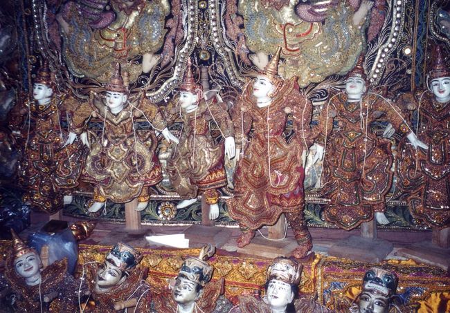 木彫と刺繍の工房見学した。沢山の職人が分業して木を刻み、あやつり人形などを作っていた。彫った後は、風や雨にさらし、アンティーク風に仕上げる。素朴な顔立ちに刺繍をほどしたコスチュームを着せる。薄暗い店一杯に所狭しと人形たちが並び、買い手を待っていた。<br /><br />ランチは、「MYAT MINGALAR」で。２階のエアコンが完備された特別室に案内されたが、道路に面したバルコニーに食事を運んでもらった。飛んでいるハエを追っ払うために、食事のあいだ中、中学生ぐらいの子がうちわであおいでくれる。 料理はここも油ッ濃い。さっとゆでたキャベツが出たがこれは独り占めした。一緒に食べていたトントンが、唐辛子をやたらご飯にかけていたので、そんなものかと試してみたが、口の中が燃えるように辛かった。むせかえり涙を流してしまい、うちわ担当の子に笑われた。<br />