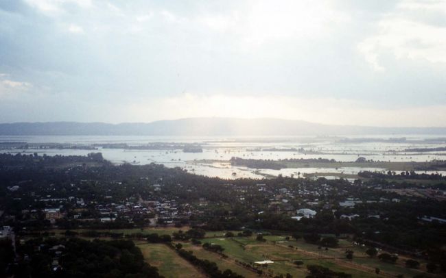 マンダレーヒル」に上がる。10年程前のトヨタ車は、急坂にあえぐ。<br />　丘の頂上には、小さなガラスをはめこんだモスクのようなパゴダが建っていた。眼下にマンダレーの市街が望まれ、後に回ると畑と山々が広がっている。日本の田舎を思い起こすような景色だ。<br />　サンセットを見るために多くの外国人たちが集まってきた。英語・中国語・フランス語・イタリア語・韓国語・日本語が聞こえる。<br /><br />日本人の6人グループの人たちは写真撮影が趣味であるらしく、見るからに高級なカメラでサンセット方向にシャッターを切っていた。かたや、私のカメラはエラーメッセージが続出して、その都度バッテリーを抜いてリセットしなくてはならなかった。<br />しかし、美しい日の入りは見ることがかなわなかった。訪れていた雨期に、期待するのが間違いだろう。でも落胆はなかった。ロンジーをはき、風に吹かれているひとときはとても心地よい。<br /><br />のどが渇いたので夕食前にトントンの薦めで、「Beer Station Myanmar Lion」 に行く。地元の人たち御用達の屋外ビアガーデンだ。つまみは焼き鳥。入り口で何本かの串を選び焼いてもらう。そして、席に着いて生ビールを頼む。<br />トントンは英語で話しまくる。・・「今度はぜひ僕の家に泊まってください。奥さんや息子さんを連れて・・。あなたのことを気に入った。」と、実にフレンドリーなことを言ってくれる。2人で「中」を6杯ほど飲んだろうか。支払いは半々でと提案してきたが、これはゲストの私がガイドの労に報いるためにも勘定を持つのは当然。1300チャット・・300円程度だった、安い!!。<br />ディナーは、「Eternal」で中華料理だった。油っこい料理に辟易していたので、これはうれしかった。<br />