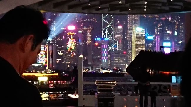 さて、途中のスーパーで金華ハムのブイヨンを大人買いし、そのままテキトーに二階建てバスに乗り込み、尖沙咀まで来ました。<br /><br /><br />アベニューオブスターズは改修工場のため立ち入りできず。その手前のスペースから、シンフォニーオブライツを見る。<br />人がたくさんいてチビッ子は普通にしてたら見えなかったので、パパの肩の上から観覧。<br /><br />曇り空にサーチライトが反射して幻想的な雰囲気でした！