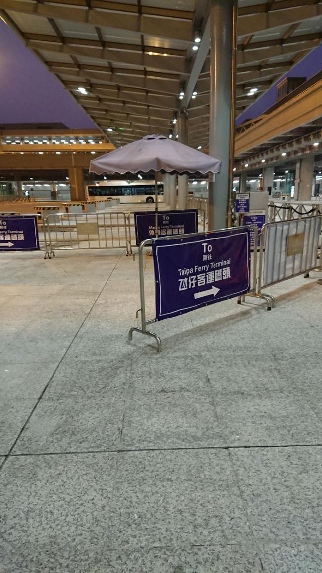 無事入国。<br />建物を出て、次はホテルを目指し移動します。<br />タイパフェリーターミナル行きの、シャトルバスが、<br />建物を出て、真ん中あたりを進むとあるはずですが。<br />but・・・わかりやすい案内表示がないので、一瞬悩みました。探しました。<br />公共市内バス乗り場は、左側。タクシーは右側。<br />シャトルバス乗り場は写真のようにフェンスに案内がありました。