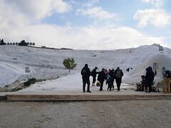 【4月21日（日）、旅行2日目】

パムッカレの石灰棚が一望できる朝食会場で食事を摂った後、早速観光に出かけます。

世界遺産である石灰棚＋ヒエラポリス遺跡のセットで、入場料は50TL（約1000円）。入り口・チケット売り場は3カ所あるようですが、私達は、ホテルからすぐの「パムッカレ村側の入り口」から入りました。
https://goo.gl/maps/zXnsfUxqwMTZF4gt8

ちなみに石灰棚では、土足厳禁、裸足になる必要があります。

【パムッカレ観光で持っていくと良いもの】
・靴を入れておく袋（リュックに入れられたら、両手が空いて良い）
・サングラス、帽子
・タオル
・（アンティーク・プールに入る場合は）水着、ビーチサンダル