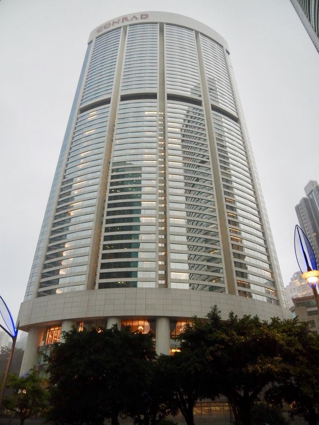 雨がザーザー降る中、香港駅からはコンプリメンタリーのシャトルバスでパシフィックプレイスまで。<br /><br />目の前にドーンとたたずむコンラッド。<br />本日はここで1泊。