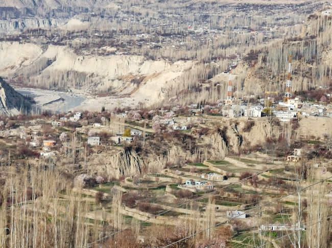 集落にズームすると･･･<br /><br />画像ではわかりにくいと思いますが、家々の周囲にはピンク色の木々が見えます。<br /><br />標高が高い（2400～2500ｍ）カリマバードではまだほとんど咲いていませんが、100～200ｍほども下るとアンズの花がきれいに咲いています。