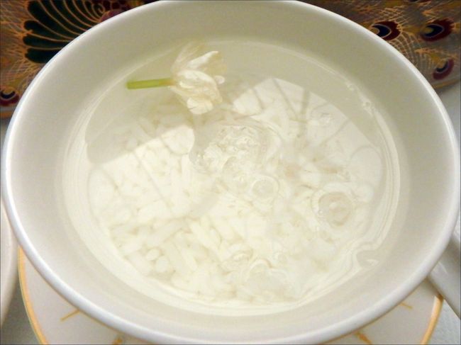 ２品目。<br /><br />ジャスミン水の中に、ジャスミンごはんが沈んだやつ。<br /><br />・・・なにこれ。(^_^;<br /><br />果たして、これは食べて良いものなのか、<br />それともフィンガーボウルか何かなのか？と迷いましたが、<br /><br />メニューを読むかぎり、やっぱり食べるもののようだったので、<br /><br />おそるおそる、スプーンでお水といっしょにごはんを掬って食べてみましたが・・<br /><br />ほんとに、なんの変哲もない、<br /><br />ただのお茶漬けならぬ「水漬け」でした。<br /><br />水もごはんも、味も甘さもまったくありません。<br /><br />ただジャスミンの香りがするだけの水とごはん。<br /><br />どれほど「うぇ～」なレベルかは、ご想像に難くないかと。。(>□<)