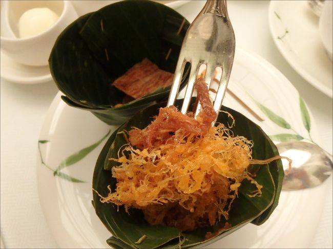 １つめの容器の中で<br /><br />ひとくちサイズの葉っぱの中に入っていたのは、<br /><br />日本で言うところの、単なる珍味ですね。<br /><br />このピリ辛のイカさきは、ど～～見ても紅茶と一緒に食べるものではないでしょう。<br /><br />ああああ。。ビール飲みたい。。冷えたビールがあぁぁ～～<br /><br />・・いや待てよ、もしかしてさっきのジャスミン水漬けごはんのトッピングのつもりだったのかなぁこれ？？？